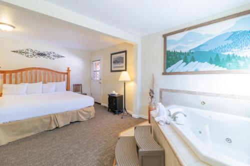 a hotel room with a bed and a bath tub at Murphy's River Lodge in Estes Park