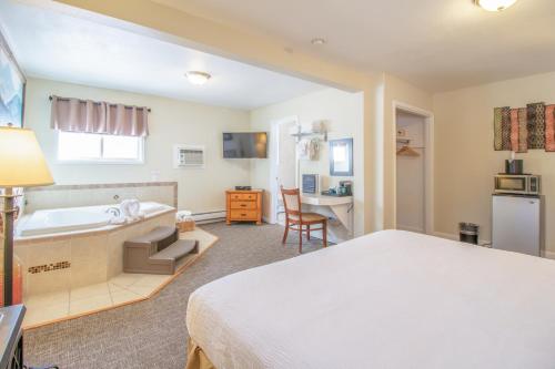 a bedroom with a bed and a tub and a desk at Murphy's River Lodge in Estes Park