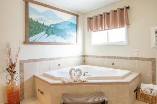 a bathroom with a bath tub with a window at Murphy's River Lodge in Estes Park