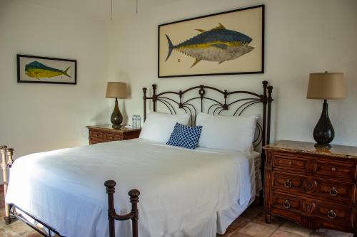 a bedroom with a bed and a fish painting on the wall at La Marina Inn in San José del Cabo