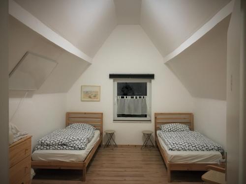 2 camas individuales en una habitación con ventana en Ferienwohnung Waldsee en Waldsee