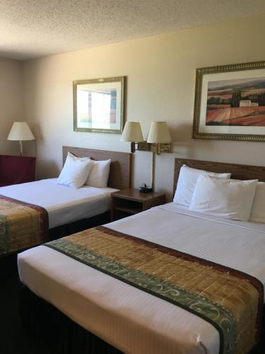a hotel room with two beds and two lamps at Cassville Four Seasons Inn & Suites in Cassville