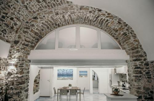 einen Torbogen in einer Küche und einem Esszimmer mit einem Tisch in der Unterkunft Cilento Apartment in Villammare