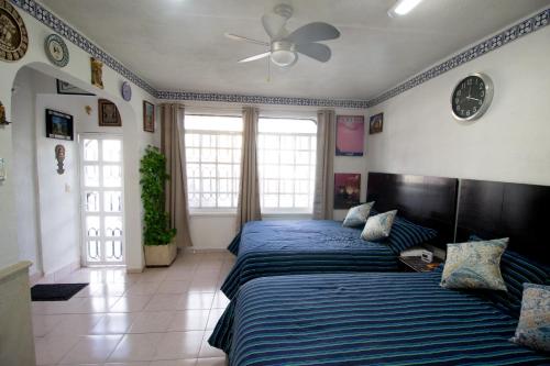 a bedroom with two beds and a ceiling fan at Casa Zac Nicte Mx-Departamento BALAM in Cancún