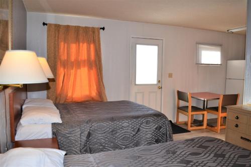 a hotel room with a bed and a table and a chair at The Villager Motel in Burstall