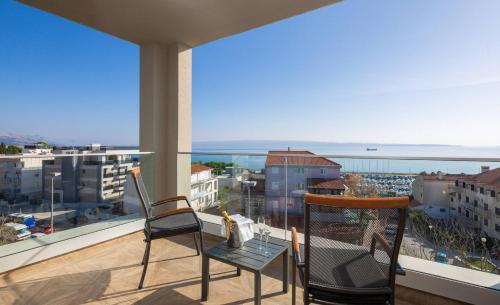two chairs on a balcony with a view of the ocean at Ellure Luxury Suites in Split