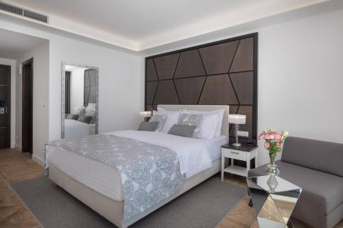 a bedroom with a large bed and a couch at Ellure Luxury Suites in Split