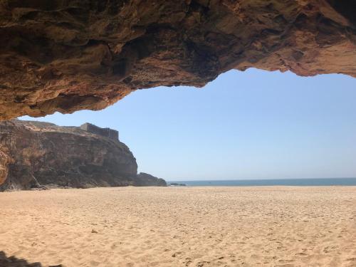 a view of the beach through a cave at L'Escale au Portugal Villa-B&B-Spa in Ataíja de Baixo
