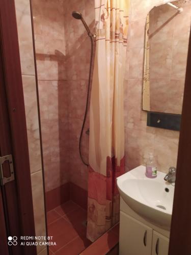 uma casa de banho com um chuveiro e um lavatório. em HOME em Chisinau