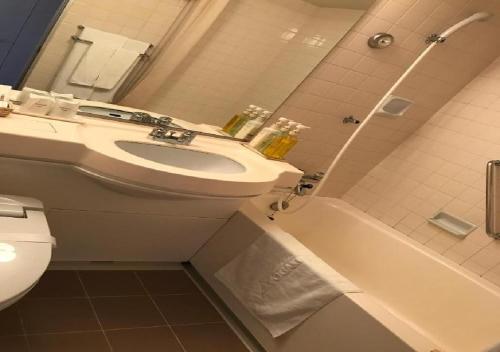 a bathroom with a sink and a tub and a toilet at Ogaki Forum Hotel / Vacation STAY 72184 in Ogaki