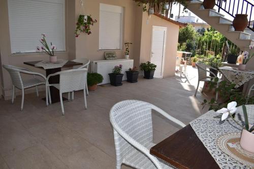 een patio met een tafel en stoelen en een trap bij Aigli Luxury Studios in Nea Roda