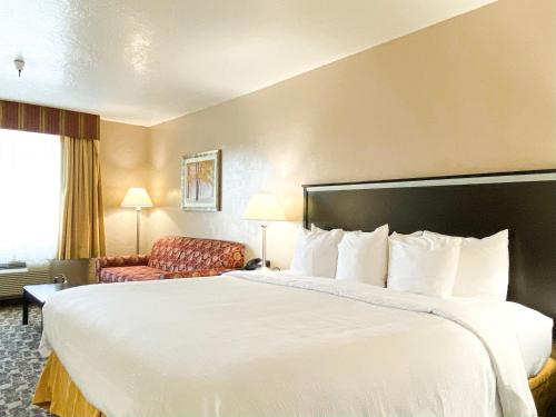 a hotel room with a large bed and a chair at Quality Inn Vernal near Dinosaur National Monument in Vernal