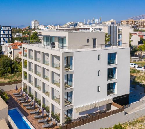 an aerial view of a white building with a pool at Ellure Luxury Suites in Split