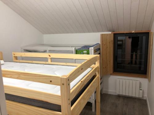 two wooden bunk beds in a room with a window at Logis de la Tonnellerie in Chambretaud