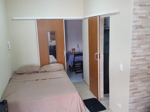 a small bedroom with a bed and a door to a room at Porto de Galinhas - Flat 6 - Residencial Lagoa de Porto in Porto De Galinhas