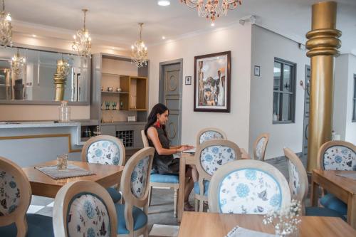 a woman sitting at a table in a restaurant at Adamas House Hotel Boutique in Quito