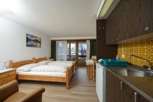 eine Küche mit einem Bett in der Mitte eines Zimmers in der Unterkunft Aparthotel Résidence Bernerhof in Wengen