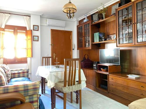 sala de estar con mesa y cocina en Hispalis San Juan de la Palma, en Sevilla