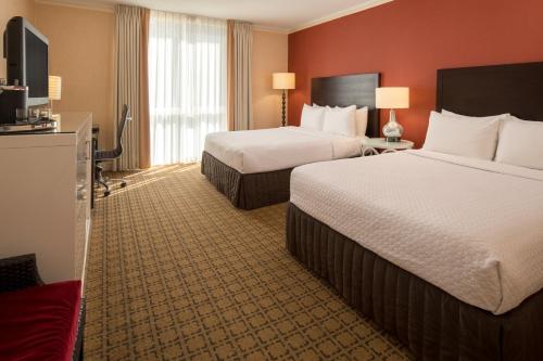 a hotel room with two beds and a flat screen tv at Crowne Plaza Cabana Hotel by IHG in Palo Alto
