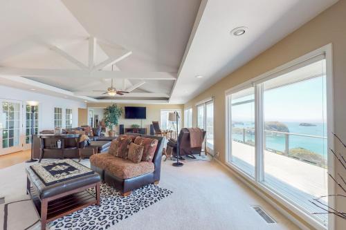 a living room filled with furniture and a large window at Whalerock Luxury Home in Trinidad