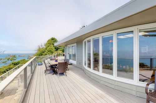 a house with a deck with a table and chairs at Whalerock Luxury Home in Trinidad