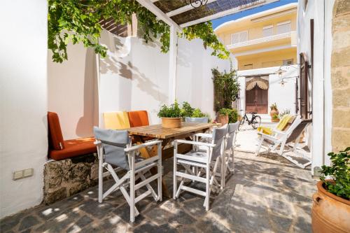 an outdoor patio with a wooden table and chairs at Villa dei Ciottoli in Rhodes Town