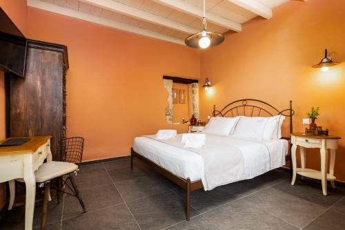een slaapkamer met een groot wit bed en een bureau bij Villa dei Ciottoli in Rhodos-stad