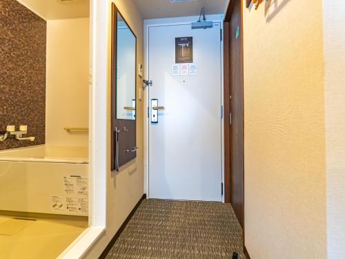 a door leading into a room with a hallway at Bande Hotel Tenpozan Higashi in Osaka