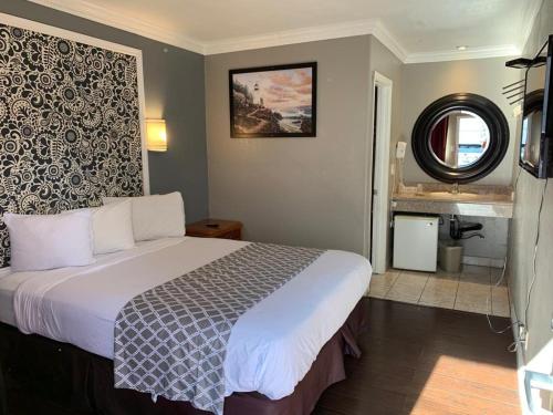 Habitación de hotel con cama y baño en Uptown Inn en Long Beach
