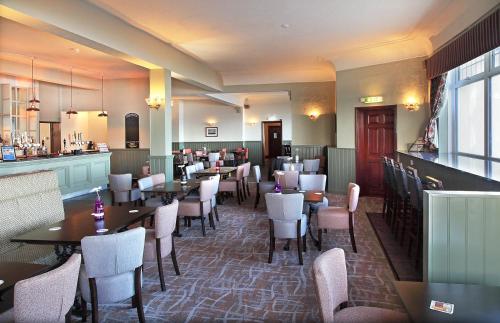 a restaurant with tables and chairs and a bar at Park Hotel in Redcar