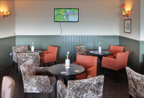 a dining room with tables and chairs and a tv at Park Hotel in Redcar