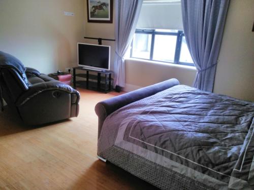 a bedroom with a bed and a couch and a window at Riverview Country House in Ballinasloe