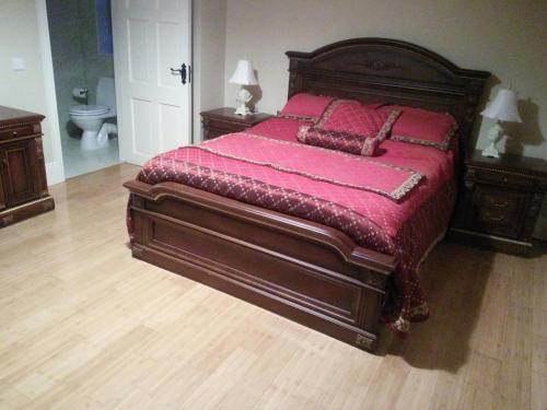 a bedroom with a large bed with red sheets and pillows at Riverview Country House in Ballinasloe