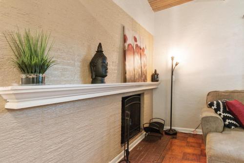 a living room with a fireplace with a statue on it at Mid-century Home 2 miles to UF, Downtown, and Shands Plus Walk to Coffee Culture, Planet Fitness and Alfred A Ring Park in Gainesville