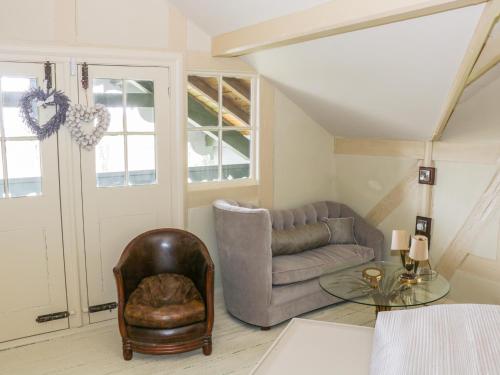 a living room with a couch and a glass table at Swiss Cottage in Mohill