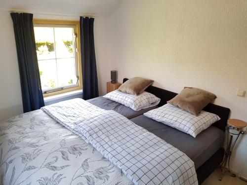 - 2 lits dans une chambre avec fenêtre dans l'établissement Vakantiebungalow De Heivliet op de Veluwe, à Putten