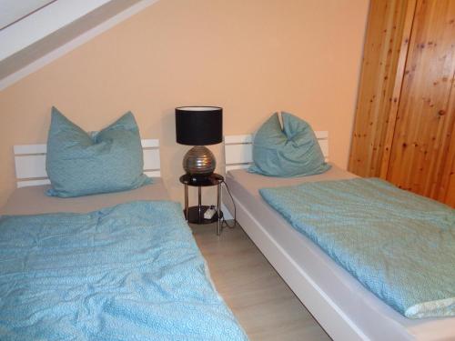 2 camas con almohadas azules en un dormitorio en Residenz Peckmann, en Gilching