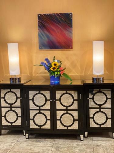 two tables with a vase of flowers and two lights at Apache Casino Hotel in Lawton