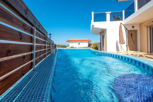a swimming pool with blue water in a house at Kolymbia Village in Kolimbia