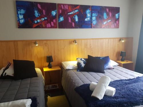 a bedroom with two beds and a painting on the wall at Abisko Lodge in Methven