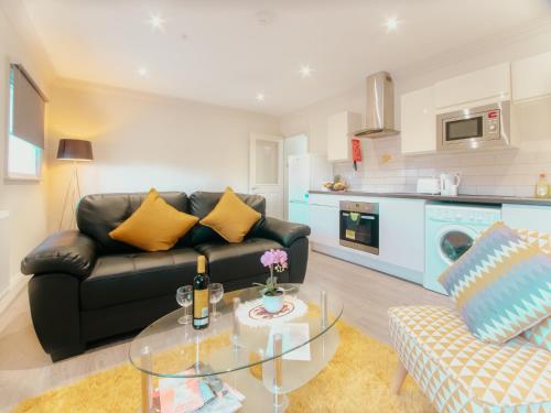 a living room with a black couch and a glass table at Spacesavers in Sheffield
