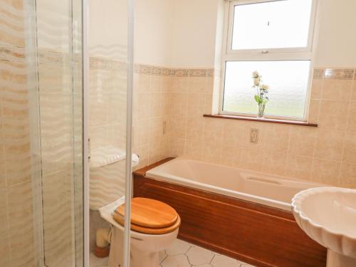 La salle de bains est pourvue de toilettes, d'une baignoire et d'un lavabo. dans l'établissement Cleary Cottage, à Miltown Malbay