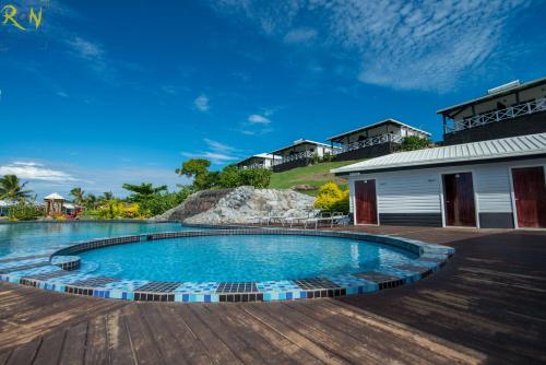 a swimming pool in a yard next to a house at Dua Dua Beach Resort in Rakiraki