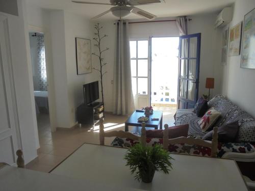 een woonkamer met een bank en een tv bij Apartamento Tres Pinos cerca de la Playa in San José
