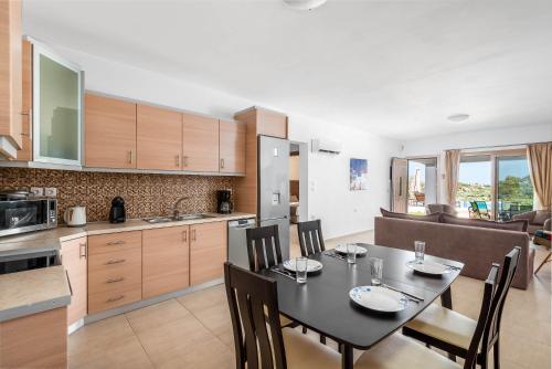 a kitchen and dining room with a table and chairs at Kolymbia Village in Kolimbia