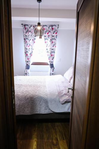 a small bedroom with a bed and a window at Apartman Filip in Novi Pazar