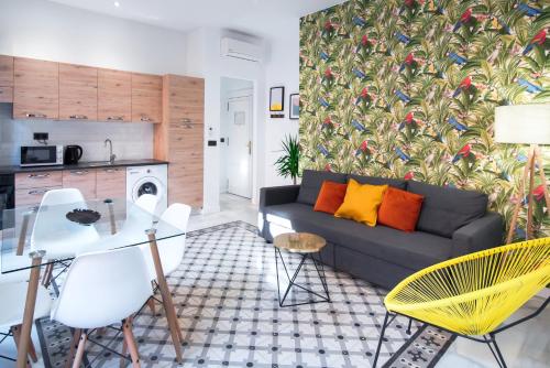 a living room with a couch and a table and chairs at Granadi Apartamentos in Granada