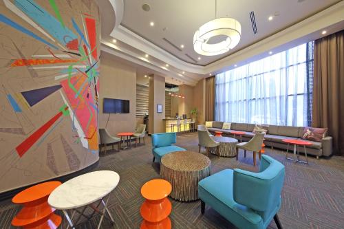 a lobby with a waiting area with tables and chairs at Novotel Panama City in Panama City