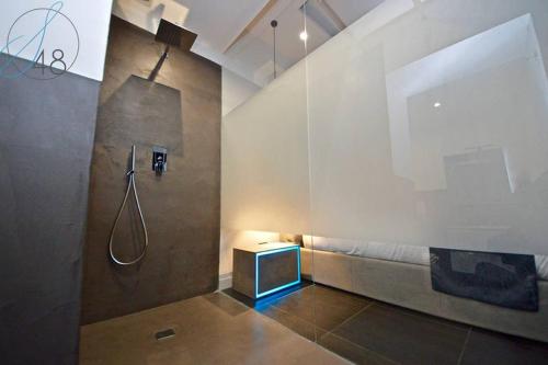 ein Bad mit einer Dusche und einer Bank mit einer Dusche in der Unterkunft Suite Quarantotto Luxury House in Neapel
