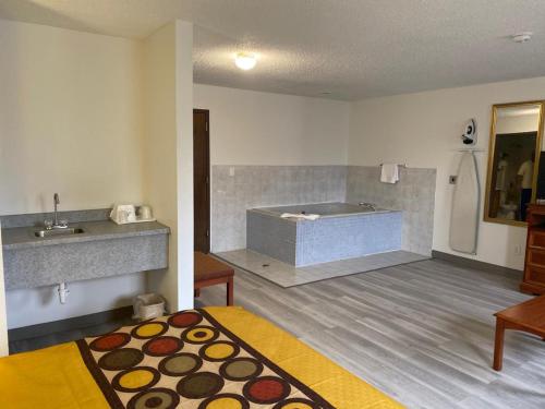 uma casa de banho com uma banheira, uma cama e um lavatório. em Americas Best Value Inn West Frankfort em West Frankfort